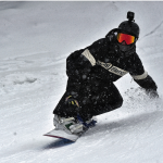 snowboarder sliding wearing black womens snowboard jackets