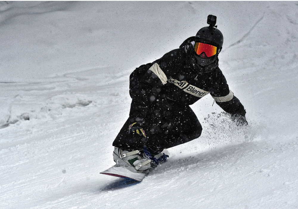 snowboarder sliding wearing black womens snowboard jackets